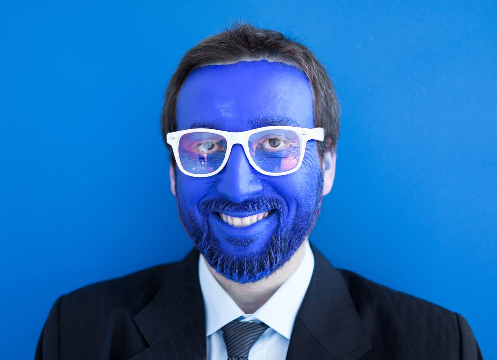 Portrait of adult man with colorful blue face